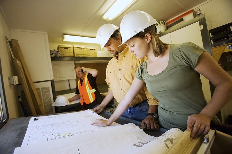 Engineers planning a custom ADU with architectural drawings.